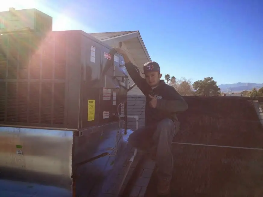 HVAC technician performing Air Duct Cleaning on a rooftop unit in Douglasville
